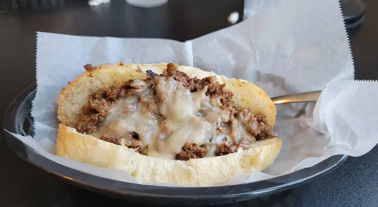 Placeholder photo: a steak sandwich with melted cheese on a white roll