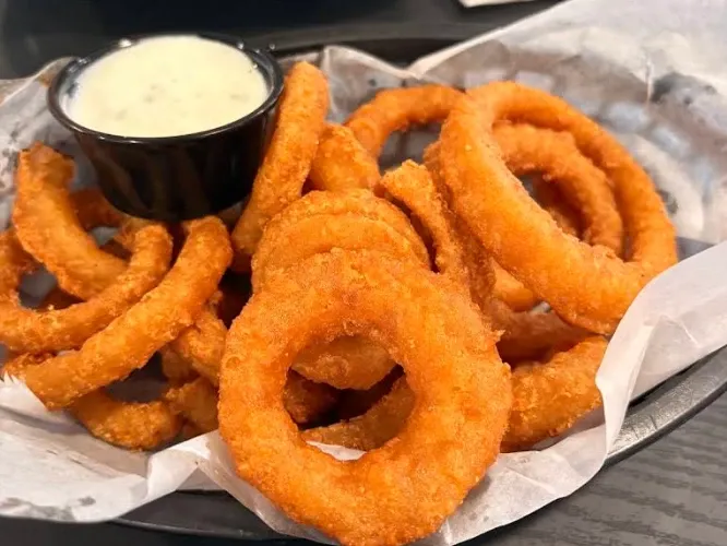 Placeholder photo: a basket of beer battered onion rings with a cup of ranch